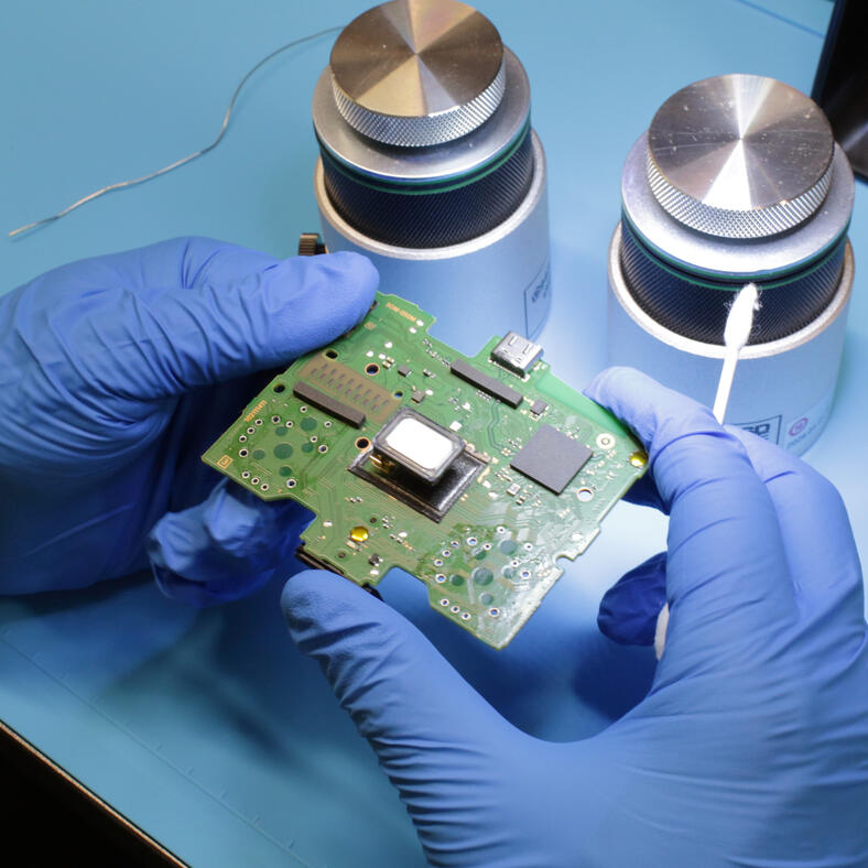 Controller circuit board being cleaned during repair